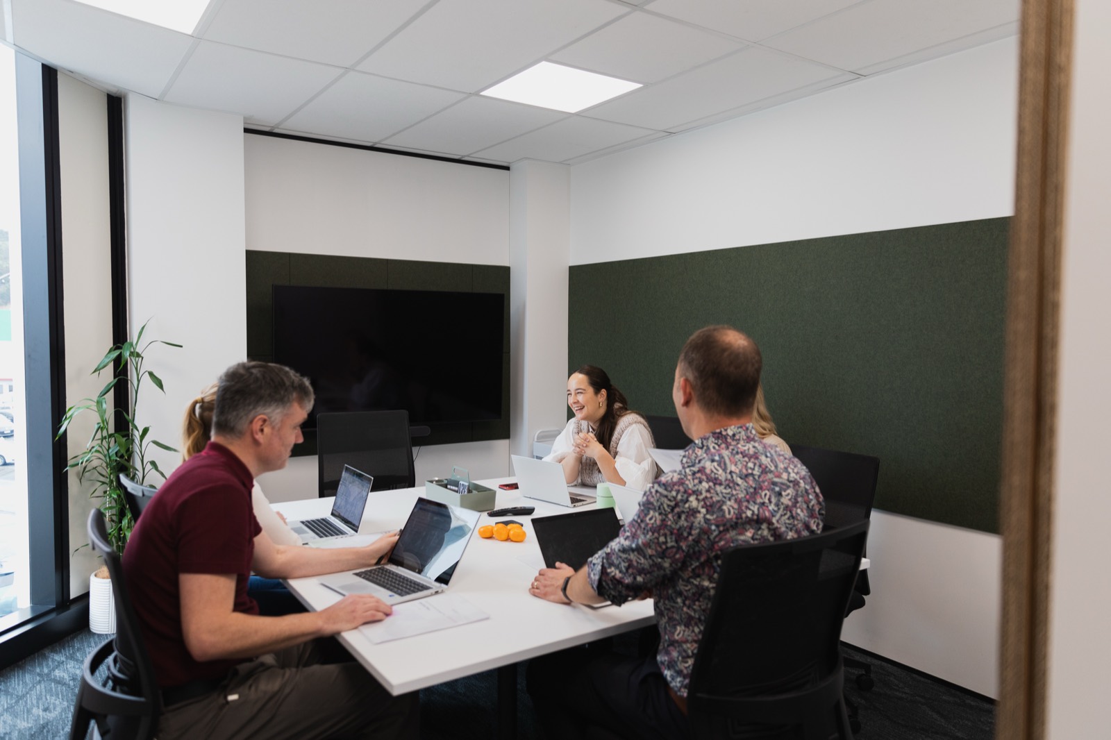 Boardroom with people meeting around a presentation screen