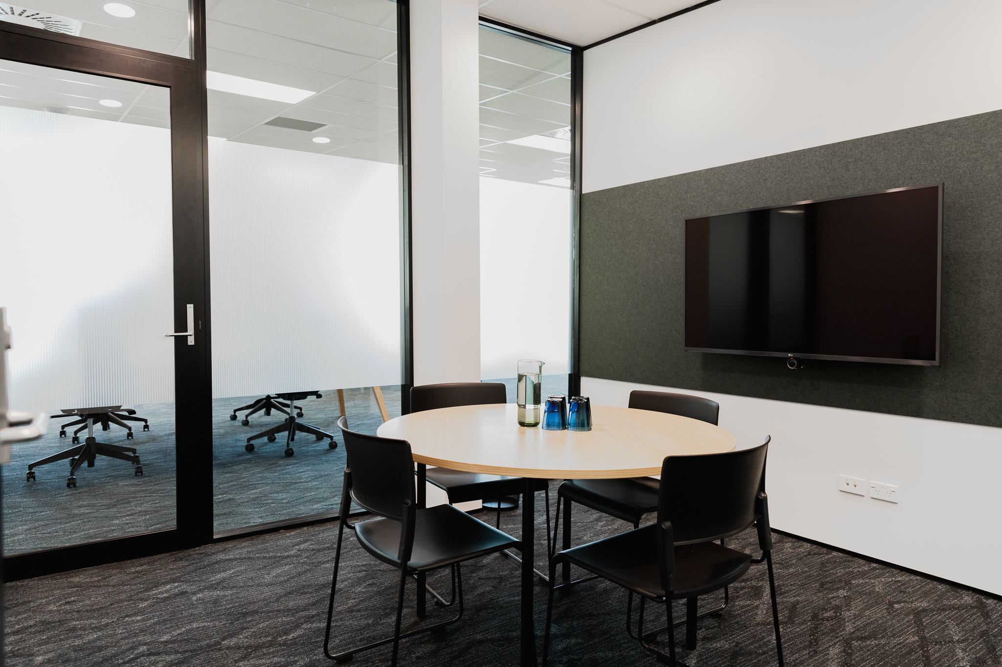 Meeting room with round table and video screen